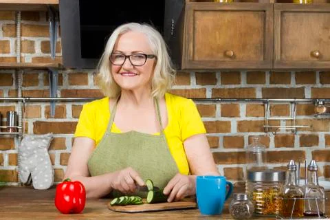 Progressive modern granny concept. Elderly woman food blogger wearing glasses 库存照片