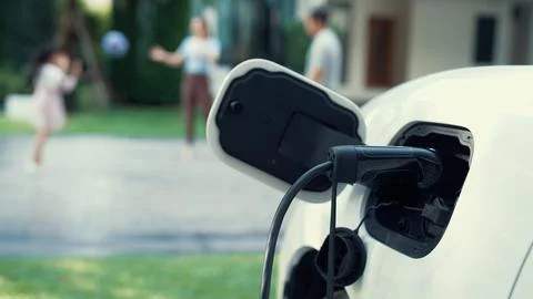 Progressive parent have returned from picking up daughter at school with EV car. Stock Photos