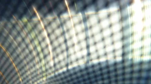 Progressive rhythmic bright light layers seen through a net fence pattern 写真素材