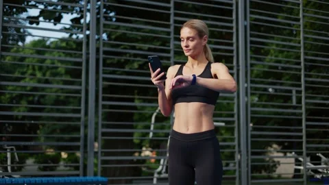 Progressive woman using smart devices for controlling efficiency of training Stock Footage 252198705