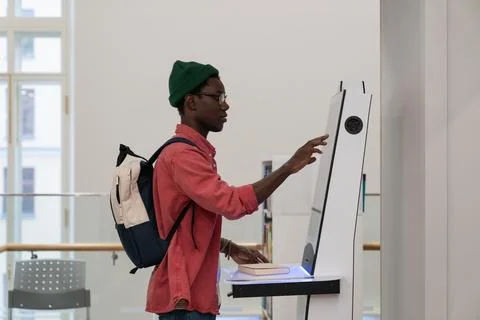 Progressive young man using self-service electronic terminal to pay in store Stock Photos