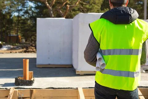 The project architect's back is on the construction site of a house with the  Foto stock