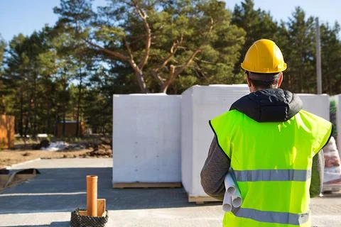 The project architect's back is on the construction site of a house with the  Foto stock
