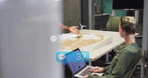 Project lead responding to rising chat alerts while explaining wind turbine Stockbeeldmateriaal 312083598