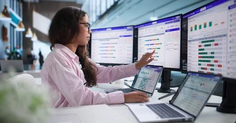 Project Manager Analyzes Team Utilization Data Using Laptop In Bright Office. Stock Photos