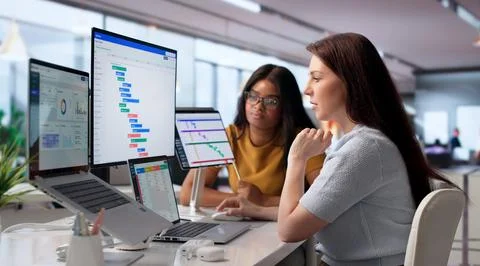 Project Manager And Assistant Discuss Schedule While Looking At Laptop Screen Stock Photos