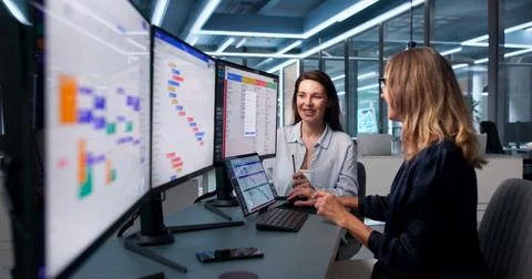 Project Manager And Assistant Discuss Plans Using Digital Calendar Together. Stock Photos