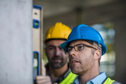 Project manager and construction worker using spirit level Stock Photos