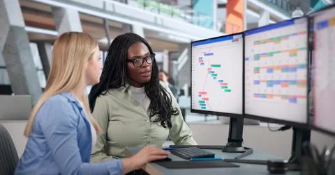 Project Manager And Team Discuss Agile Tasks Using Computer In Office. Stock Photos