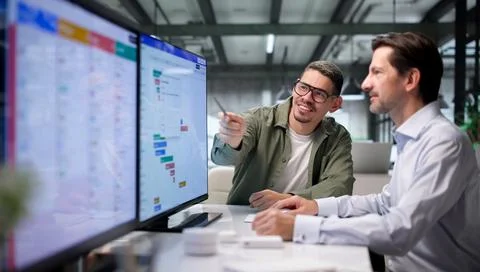 Project Manager And Team Member Closely Review Detailed Schedule Chart Togeth Stock Photos