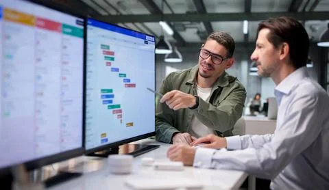Project Manager And Team Member Closely Review Detailed Project Schedule Char Stock Photos