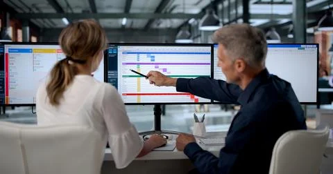 Project Manager And Team Study Gantt Chart Progress On Office Screens Togethe Stock Photos