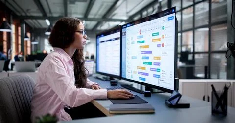 Project Manager Carefully Studies Gantt Chart On Computer To Track Progress. Stock Photos