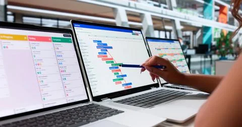 Project Manager Checks Agile Task List While Updating Office Diary. Stock Photos