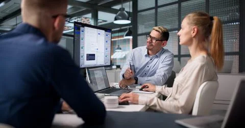 Project Manager Guides Diverse Team Using Software To Improve Workflow. Stock Photos