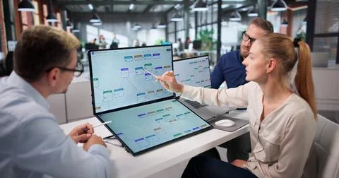 Project Manager Guides Diverse Team Using Automation Software For Workflow Op Stock Photos