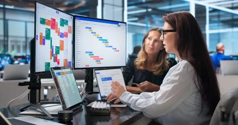 Project Manager Points At Gantt Chart While Team Discusses Project Progress T Stock Photos