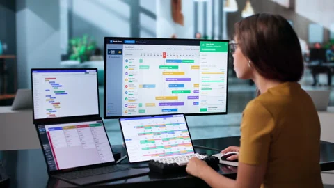 Project Manager Reviews Team Progress Using Dual Touchscreen Laptops Stock Footage 345862157