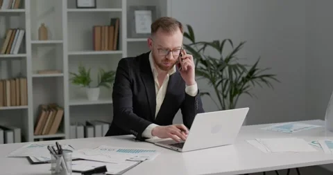 Project manager sitting at office center, having a talk on his smartphone. Stock Footage 249181462