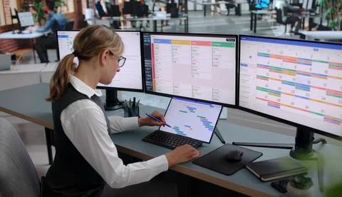 Project Manager Updates Team Report On Laptop During Busy Office Day. Stock Photos