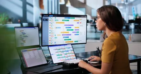 Project Manager Uses Dual Touchscreen Laptops To Review Team Progress. Stock Photos