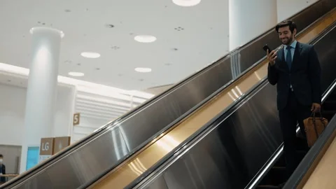 Project manager using phone calling while using escalator. Side view. Exultant. Stock Footage 265907808