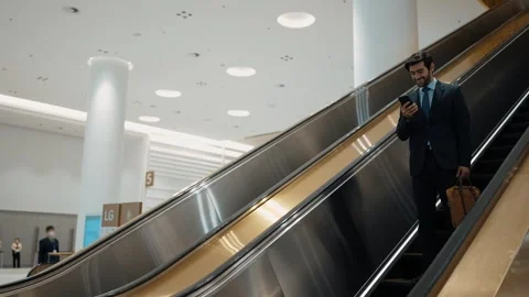 Project manager using phone calling while using escalator. Side view. Exultant. Stock Footage 277025101