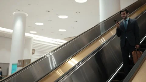 Project manager using phone calling while using escalator. Side view. Exultant. Stock Footage 283885442