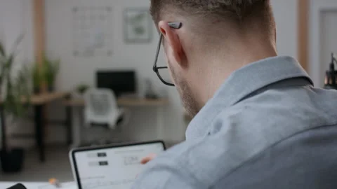 Project manager working at his desk in modern office on tablet computer Stock Footage 316600720