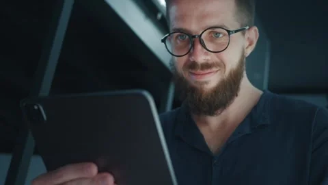 Project Manager working from home at night, holding tablet computer and smiling Stock Footage 312123196