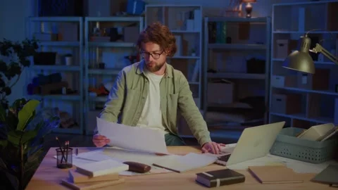 Project Planning. Focused Professional Man Working Late with Blueprints Stock Footage 318230386