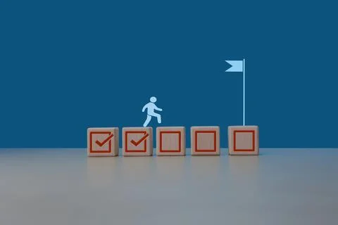 Project progress Businessman steps on task check mark to completion flag Stock Photos