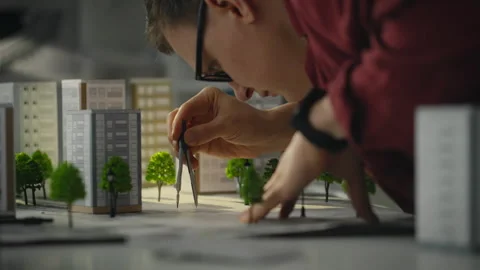 Project. A young male worker uses tool while working concentratedly with dra Stock Footage 270429738