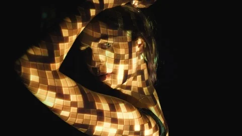 Projected disco ball pattern on face and arms of attractive, young woman. Stock Footage 77402067