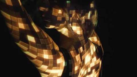 Projected disco ball pattern on face and arms of attractive, young woman. Stock Footage 77402101