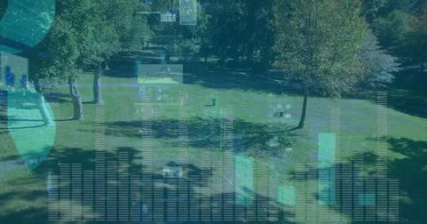 Projecting translucent bar charts line graphs and globe icons over park lawn, Fotos de archivo
