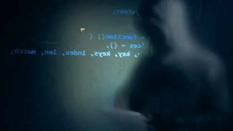 Projection of a computer display and a blurred silhouette of a male hacker Stock Footage 101580554