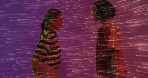 Projection system casting horizontal streaks onto two women standing in profile Stock Footage 318474541