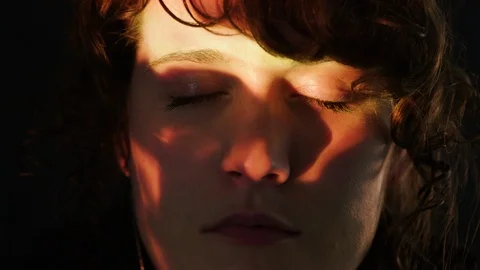 Projections of hot flames light up the face of a young woman with eyes closed Stock Footage 101979210