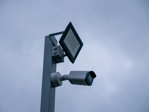 Projector and CCTV camera in gray sky background Stock Photos