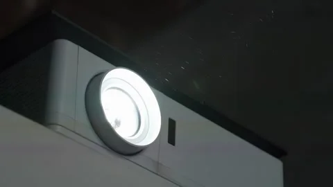 Projector lens in operation. Dust in cinema hall is visible in rays of light Stock Footage 279248337