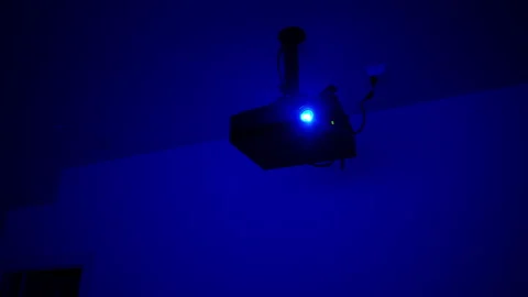 Projector in operation, visible in ray of blue light Stock Footage 295970275