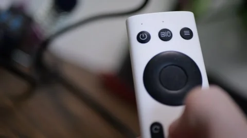 Projector remote control operated periodic button presses close up hand motion Stock Footage 320897350