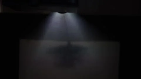 The projector shines on the canvas in the dark Stock Footage 288014773