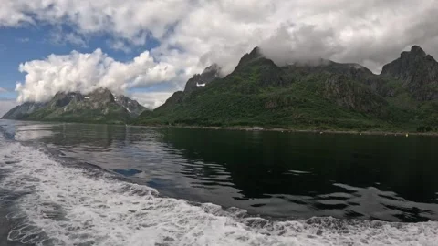 Prominent boat wake on left side navigating calm fjord with sunny sky in Lofoten Stock Footage 344753134