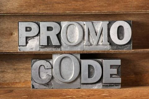 Promo code tray promo code phrase made from metallic letterpress type on w... Stock Photos