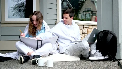 Prompting solution of problem boy and girl sitting on street doing school Stock Footage 239505087