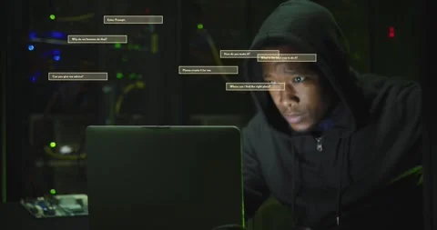 Prompts appearing, hooded tech leaning toward laptop near server rack, triaging Stock Footage 331165713