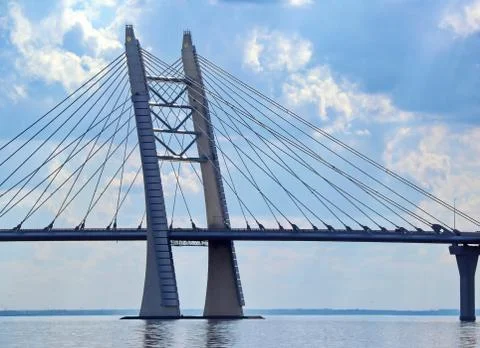 Prop of the cable bridge across the river against the background of clouds Stock Photos