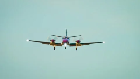 Propeller airplane landing approach beneath clear blue sky with landing gear 動画素材 342501713